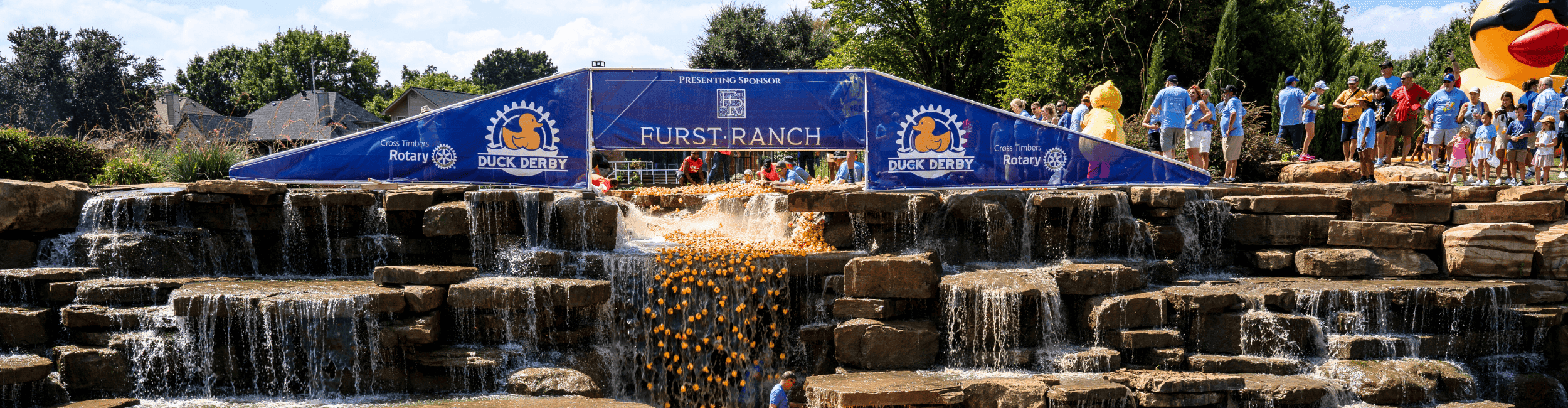 The Duck Derby banner over the waterfall at The River Walk in Flower Mound