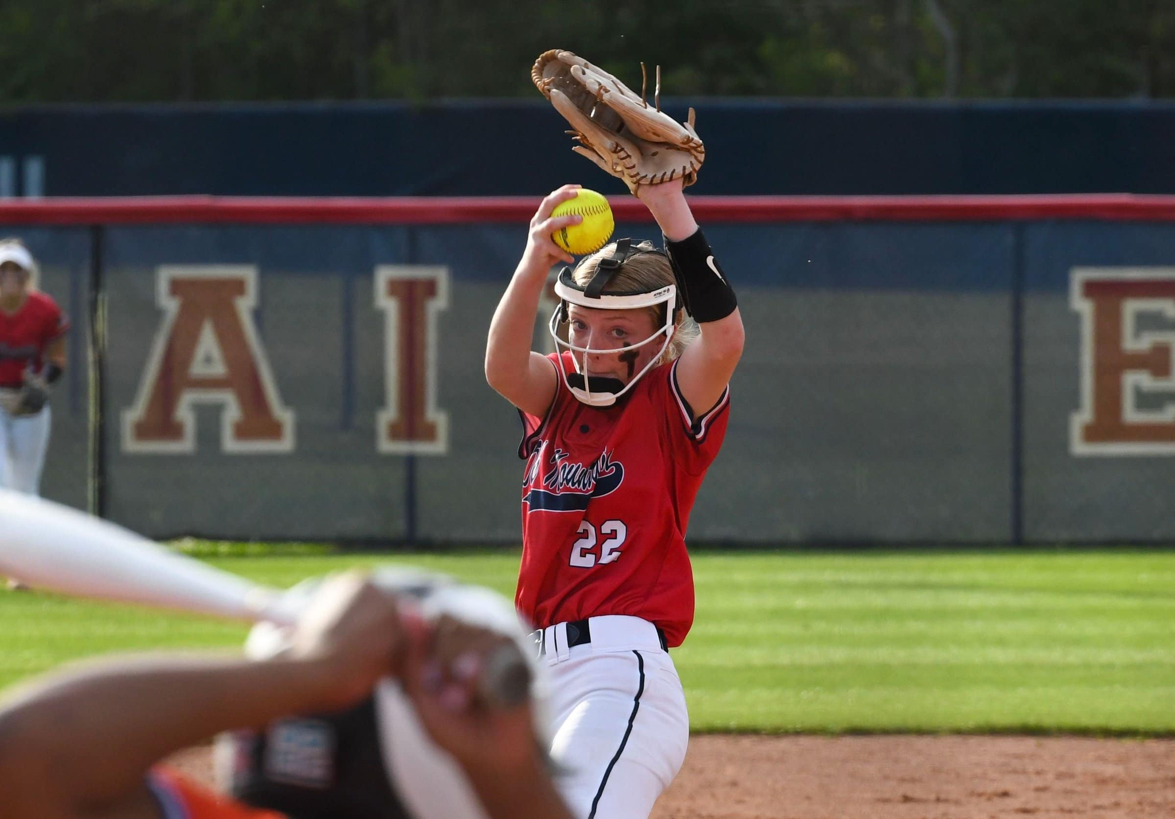 An Oak Mountain Eagles pitcher in a red jersey mid-windup